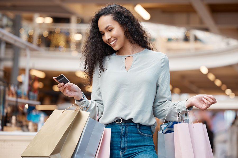 Happy woman with a shopping card and bags