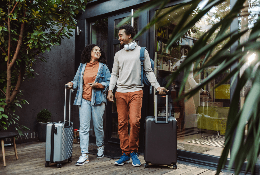 happy young couple with suitcases in holiday home