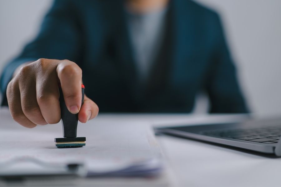 Man putting Visa stamp on documents 